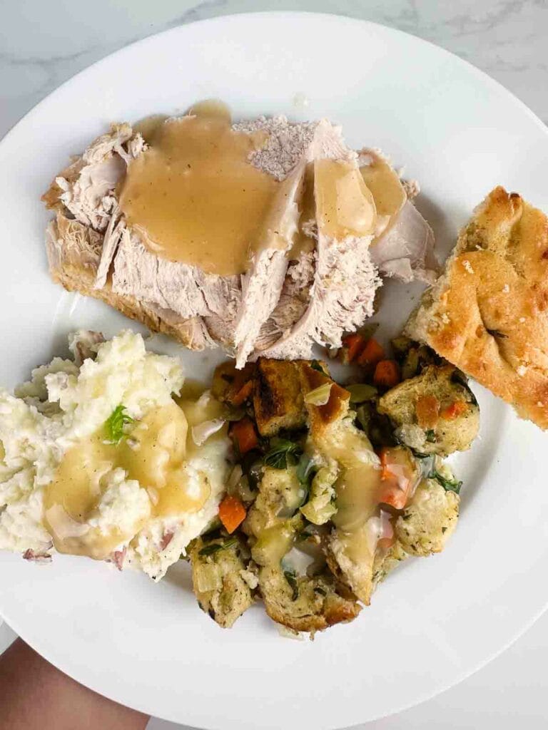 Plate of turkey, gravy, corn bread, mashed potatoes, and stuffing.