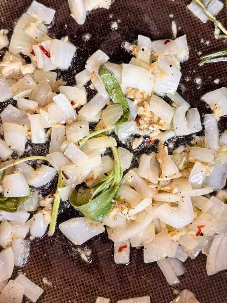 Sauteing sage, onions, and garlic in butter.