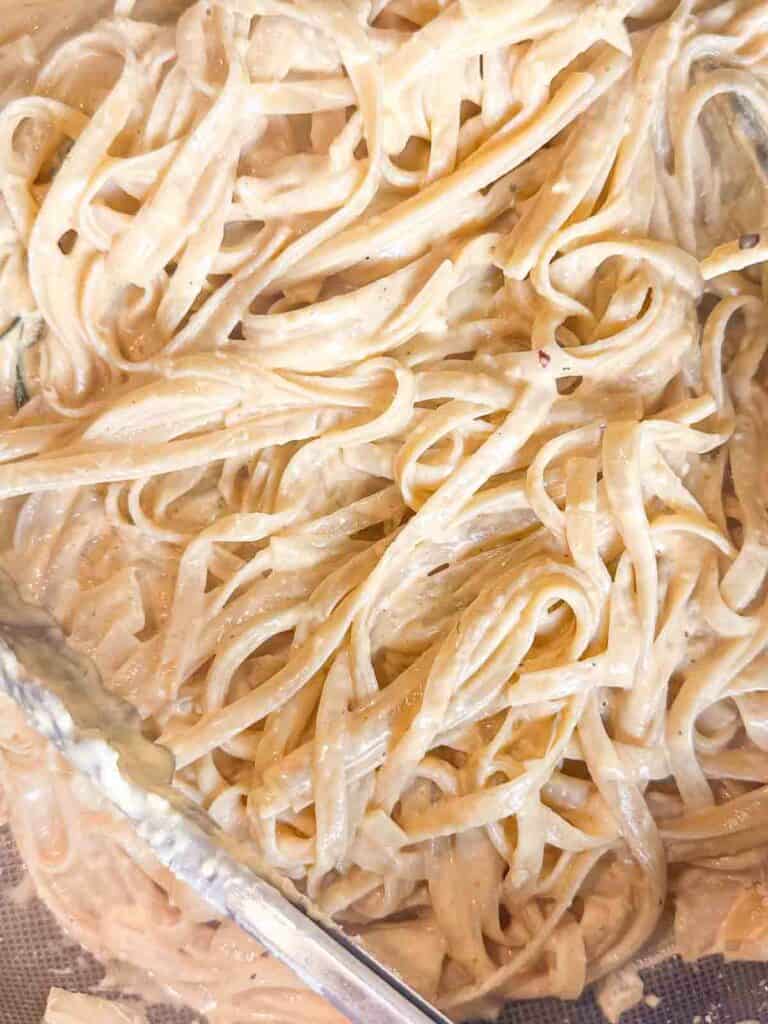 Tossing pasta with creamy pumpkin sauce.