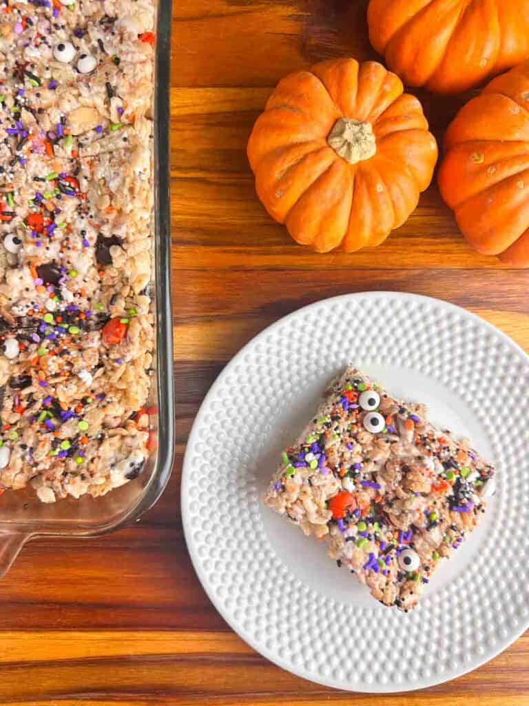 Halloween Rice Krispie Treats with pumpkins next to them.