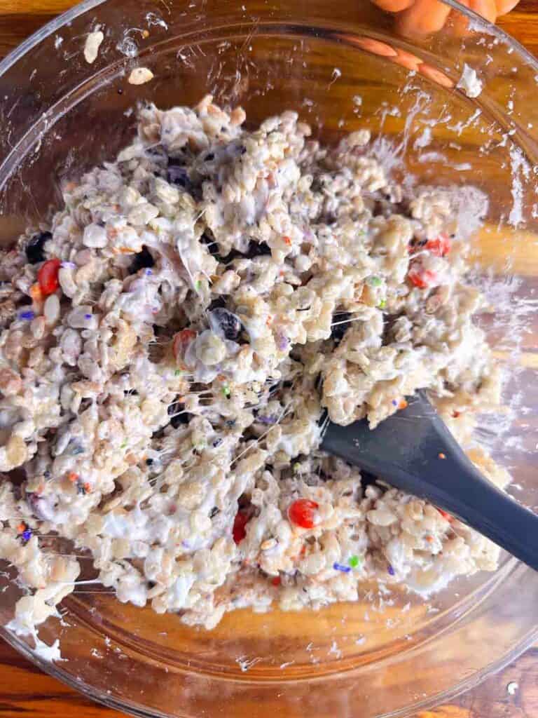 Mixing Rice Krispie treats with a spatula.
