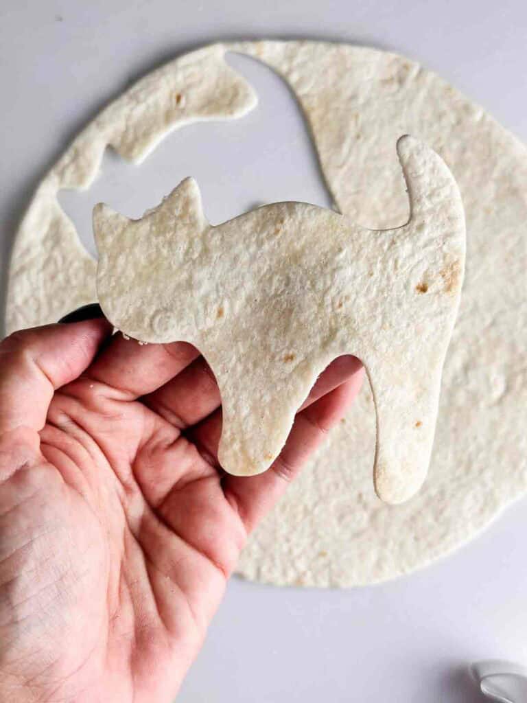 Cut the Halloween tortilla chips using a Halloween cookie cutter like a black cat