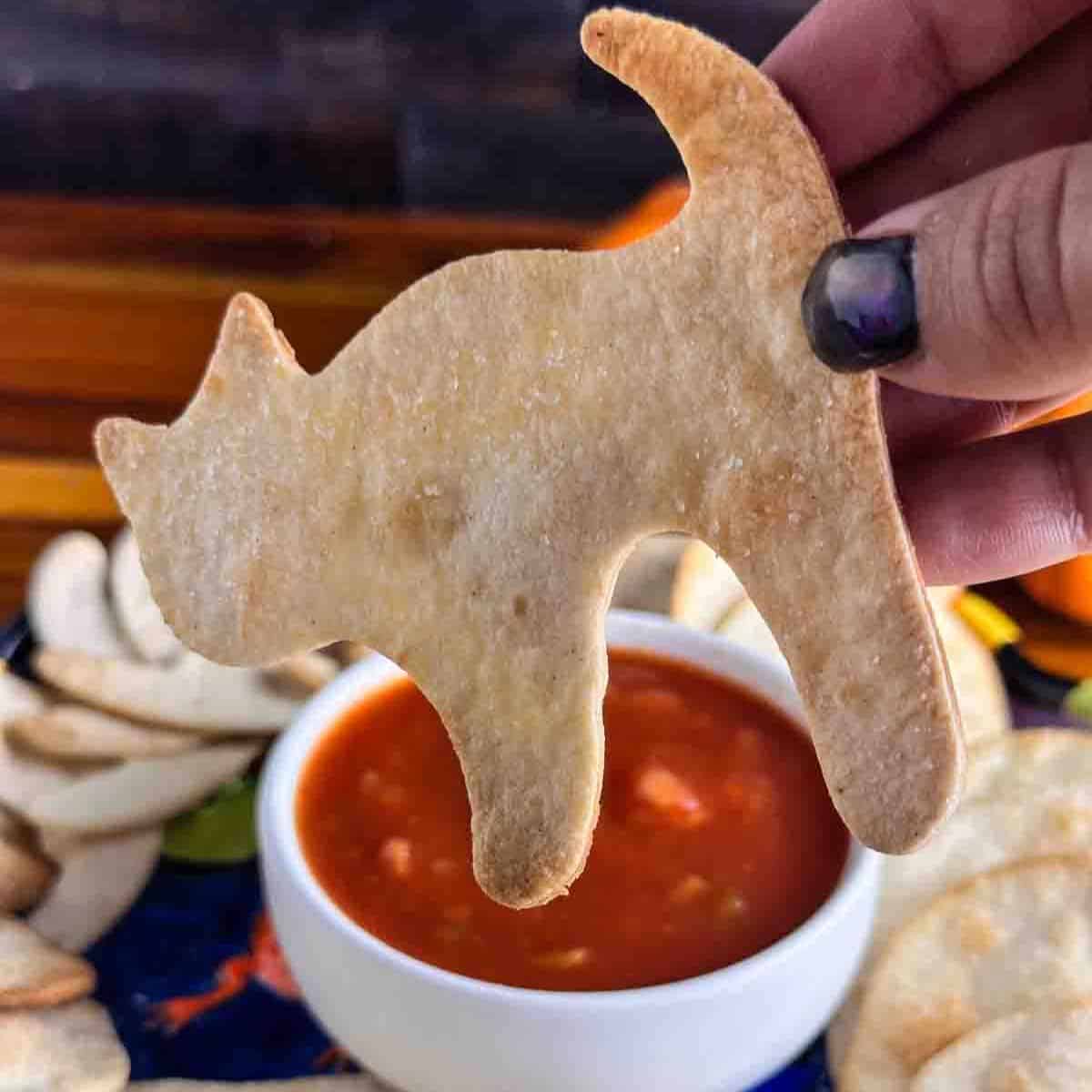 A halloween tortilla chip shaped like a black cat