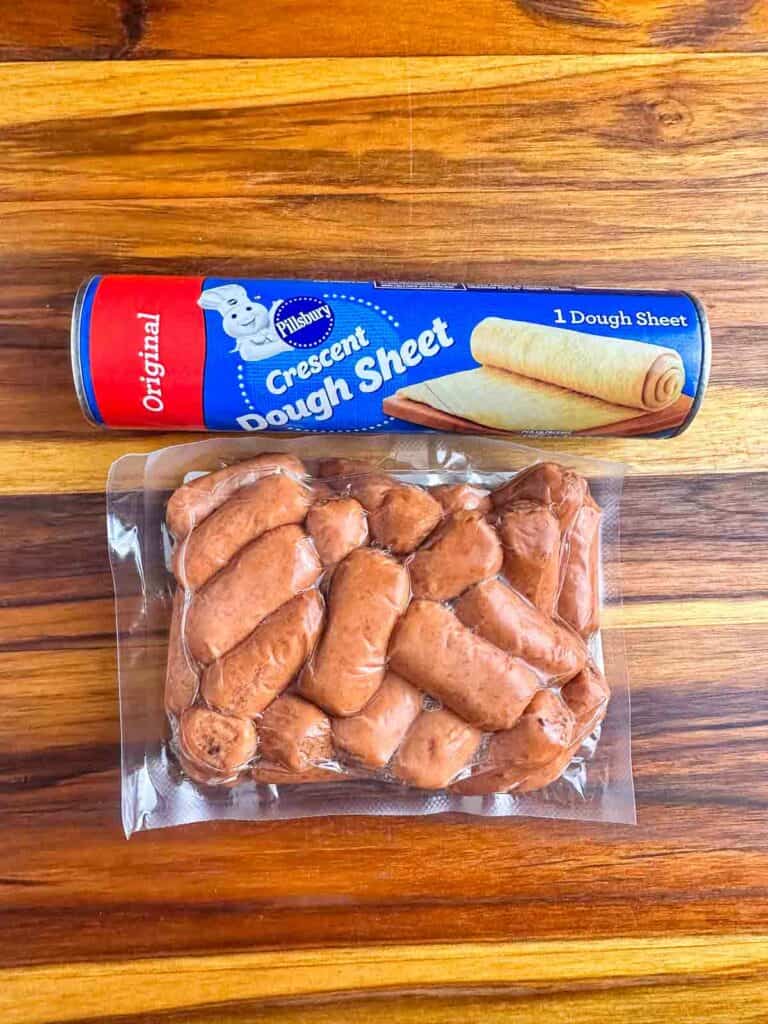 Ingredients for pigs in a blanket recipe: crescent dough sheet and mini hotdogs.