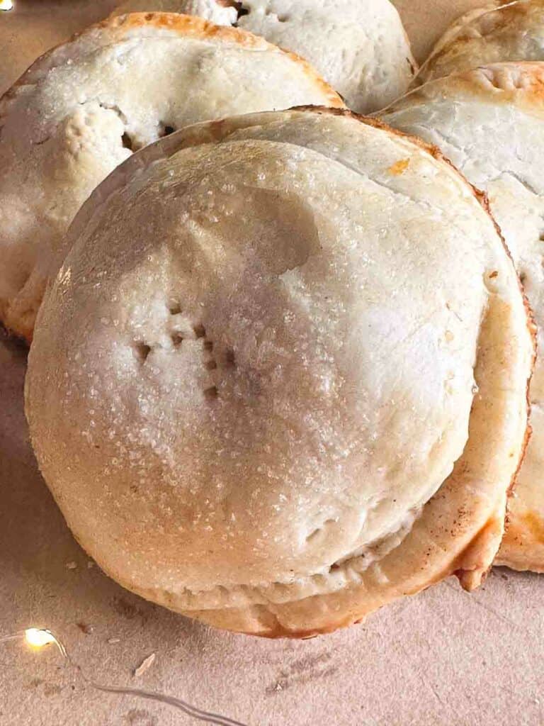 Mini apple pies on a neutral background.