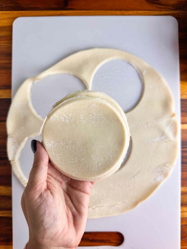 Cut out roughly equal slices of pie crust for the tops and bottoms of mini apple pies.