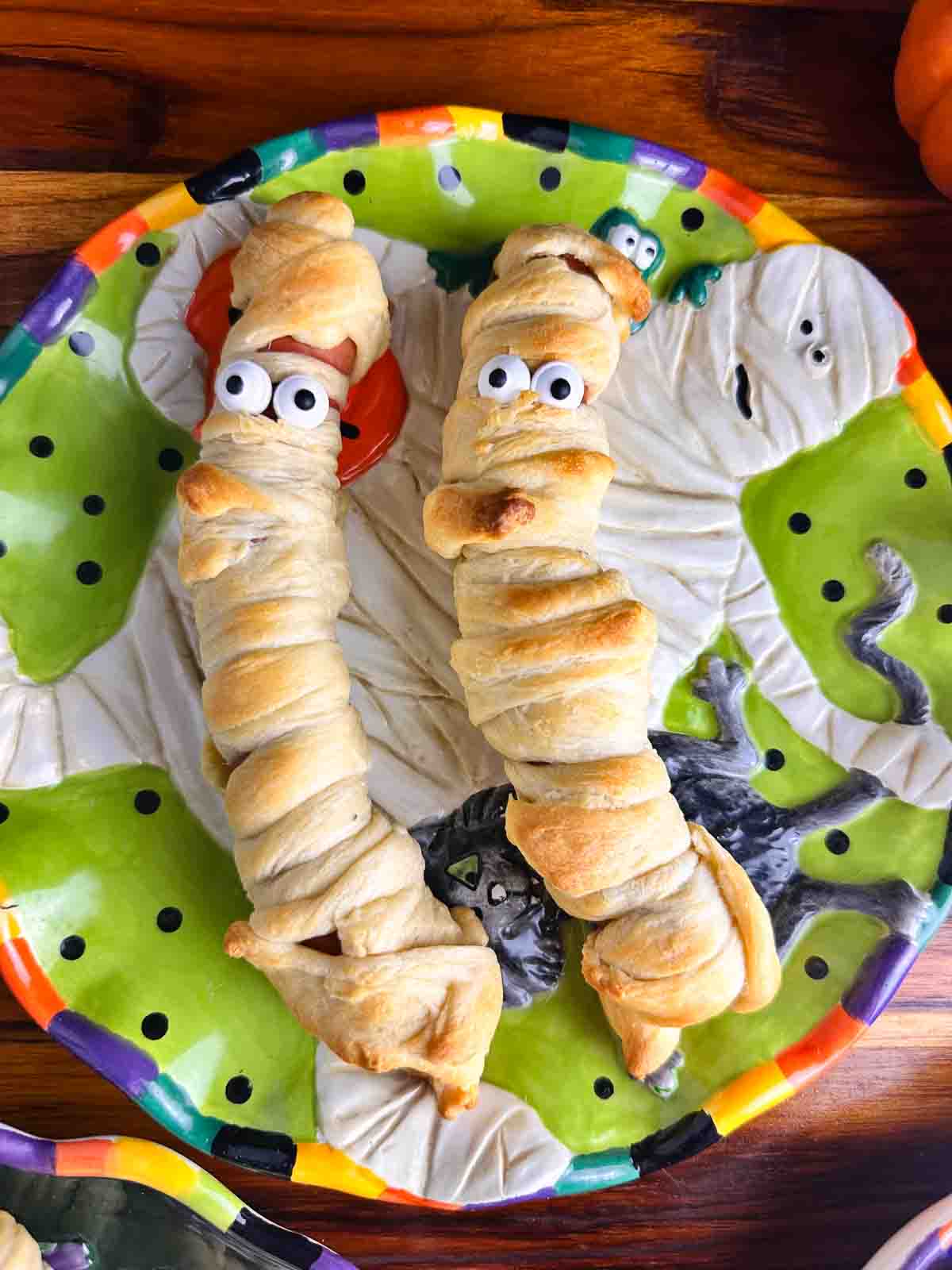 Plate of mummy hot dogs ready to eat.