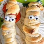 Plate of mummy hot dogs ready to eat.