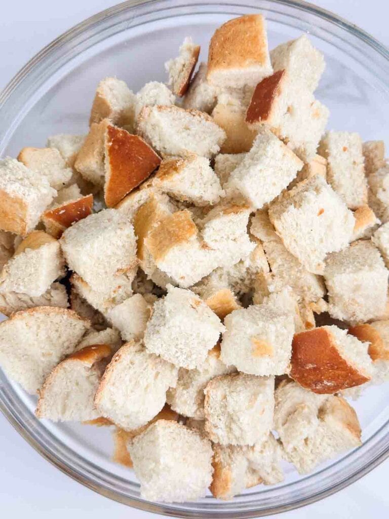 Sourdough bread cut into chunks and placed in a mixing bowl to make sourdough stuffing.