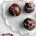 Chocolate peanut butter balls on a clear plate. Text reads: chocolate peanut butter balls, seasonedsprinkles.com