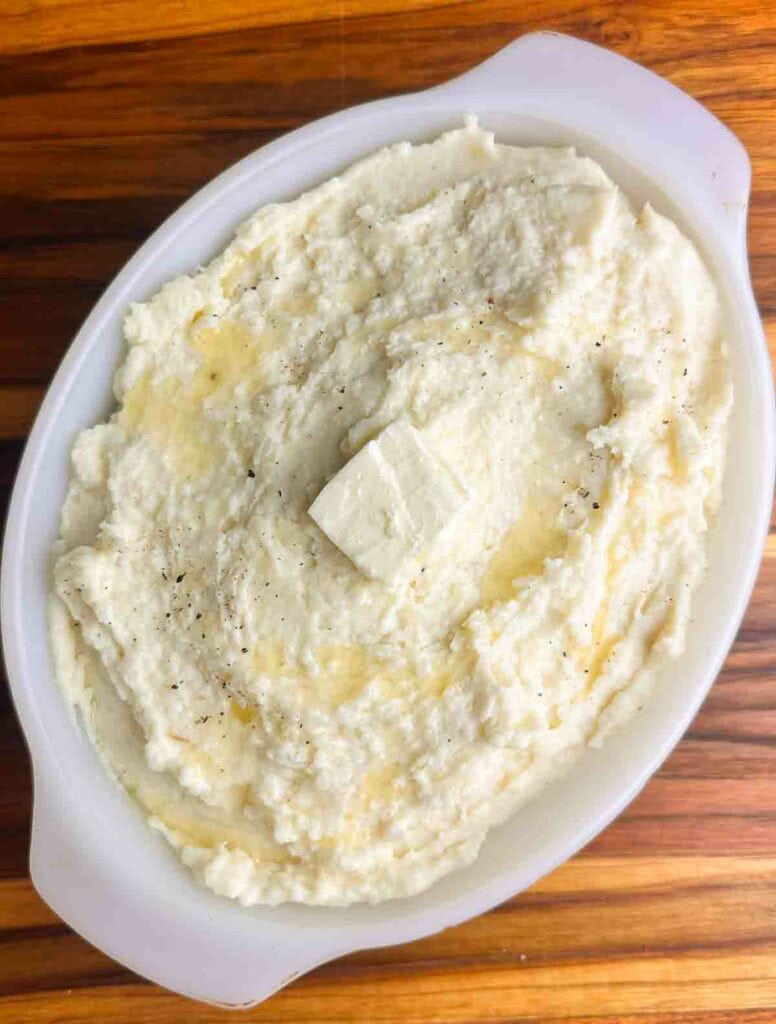 Cheesy mashed potatoes with freshly cracked black pepper and butter.