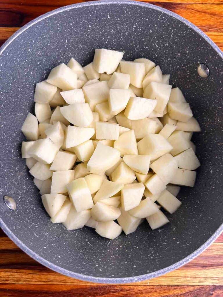 Add cubed potatoes to a pot to boil.