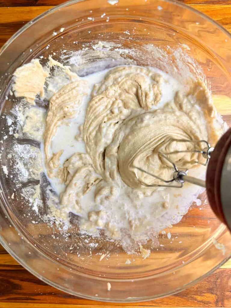 Mixing in the milk and orange juice to make the cranberry orange bread batter.