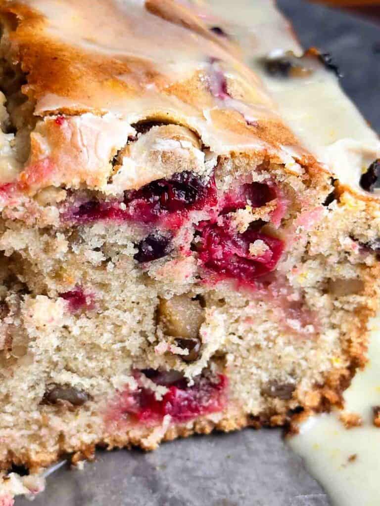 Cranberry orange bread with walnuts on a serving tray.