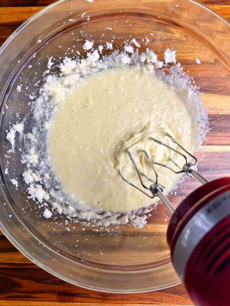 Creaming butter and eggs together for cranberry orange bread with walnuts.