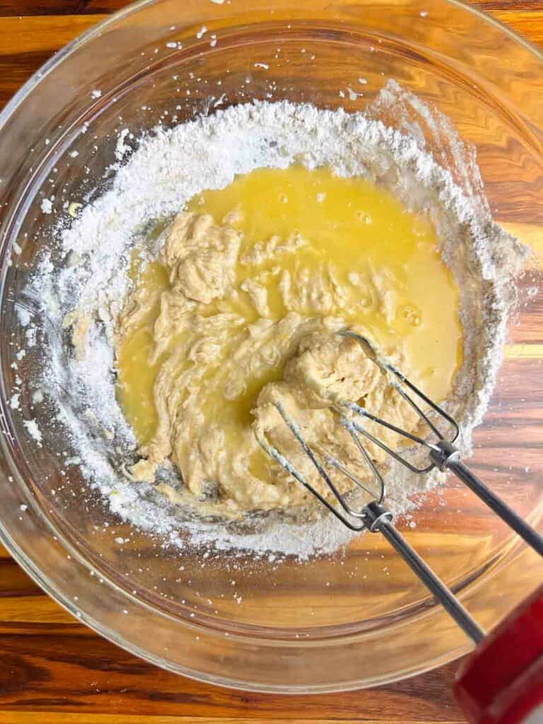 Mixing in the orange juice for cranberry orange bread batter.