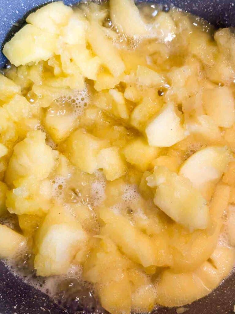 Cooking apples for a homemade applesauce recipe until the apples start to fall apart