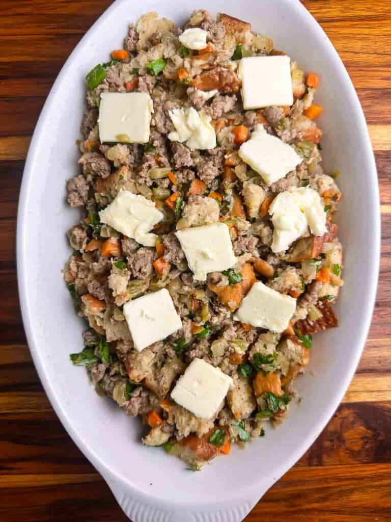 Place pats of butter over the top of the stuffing before baking.