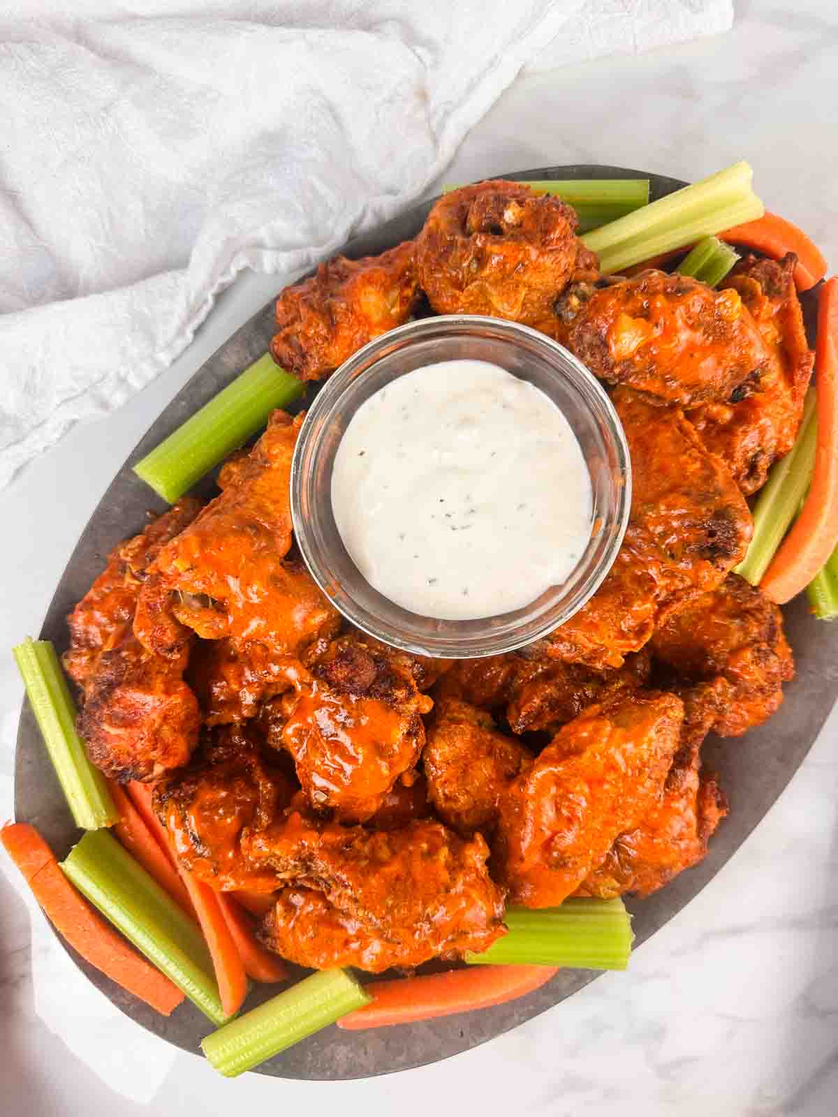 Tray of homemade buffalo chicken wings with celery, carrots, and blue cheese.
