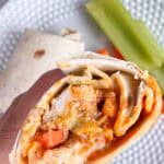 Hand holding a buffalo chicken wrap.
