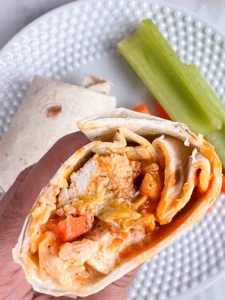 Hand holding a buffalo chicken wrap.
