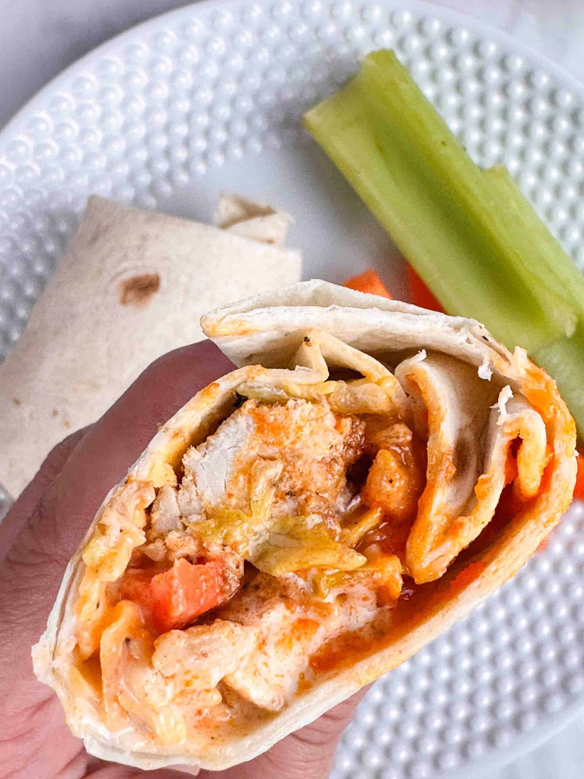 Hand holding a buffalo chicken wrap.