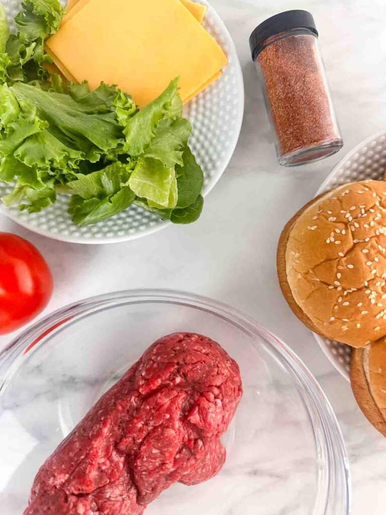 Ingredients for simple burger recipe: ground beef, hamburger seasoning, buns and fixings