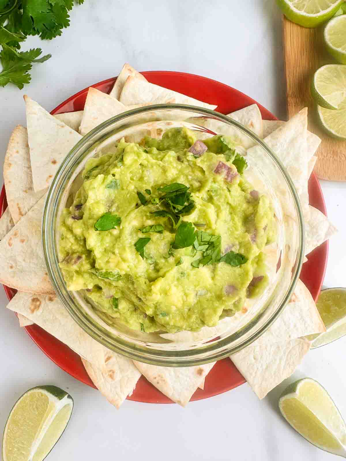 Guacamole recipe shown served on a plate with chips.