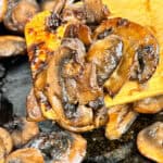 Sauteed mushrooms still in the pan being removed to serve.