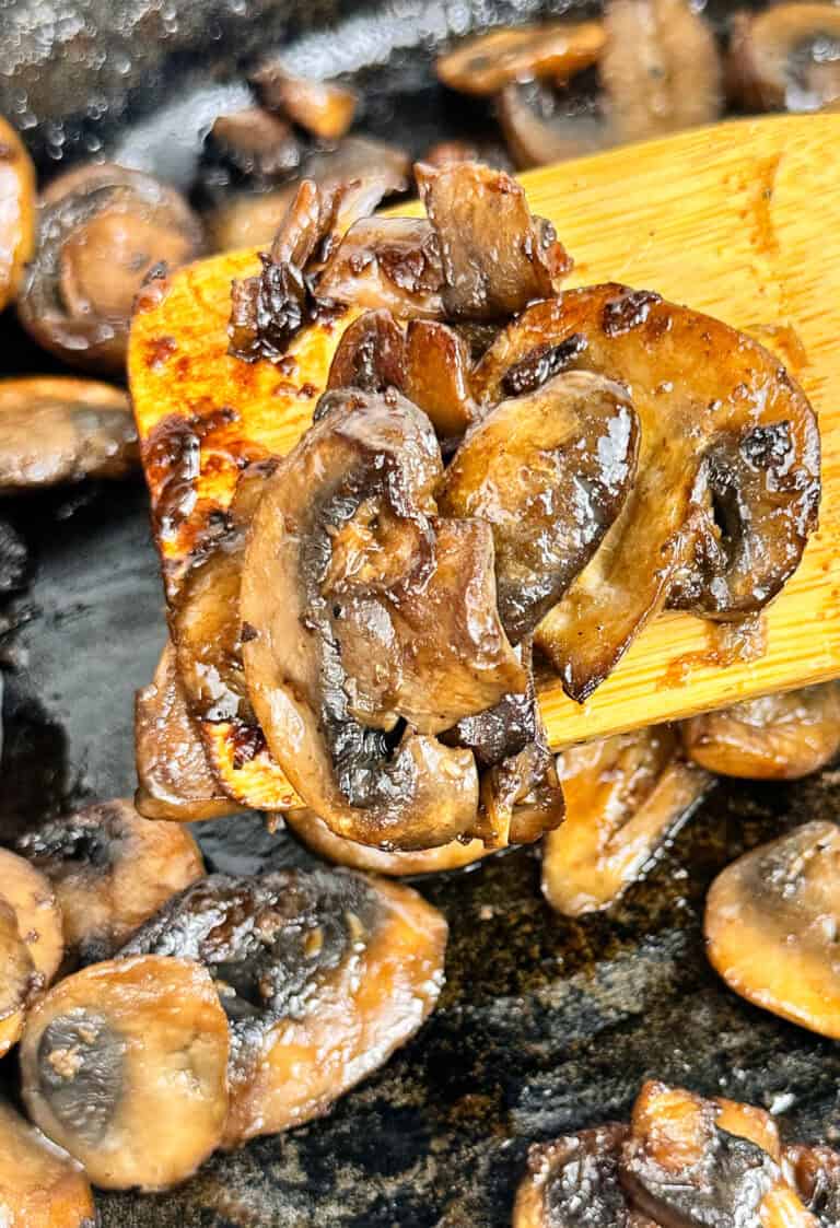 Sauteed mushrooms still in the pan being removed to serve.