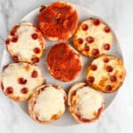 Mini pizza bagels arranged on a plate.