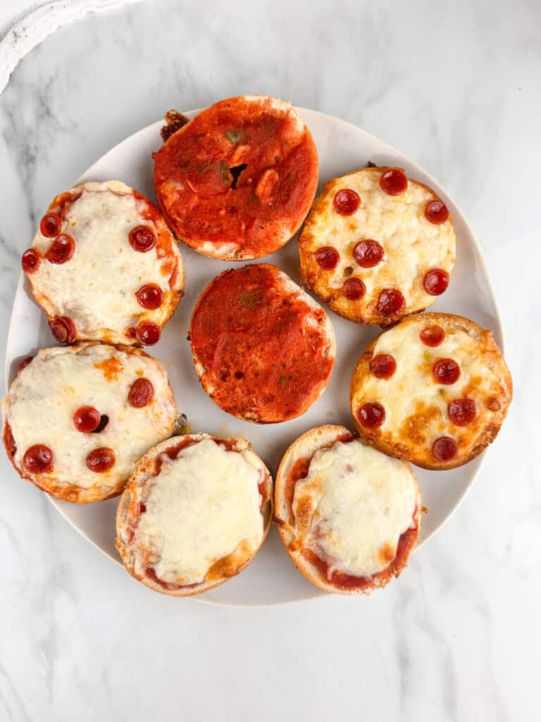 Mini pizza bagels arranged on a plate.